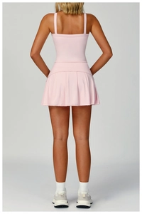 Back view of pink pleated tennis dress featuring square neck and double straps