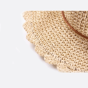 Détail du chapeau de paille tissé à la main avec bord festonné et lanière en cuir