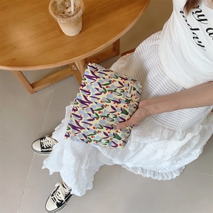 Detail of tulip printed canvas makeup bag with secure zipper and brand tag