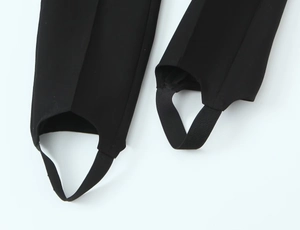 Detail of elastic stirrup strap on black leggings featuring a fine knitted texture