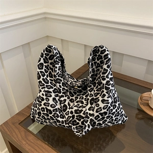 Large leopard print woven shoulder bag in black and white on a modern glass table