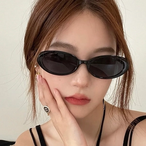 Vintage oval black sunglasses with PC lenses worn by a model for a stylish retro look