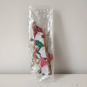 Three wooden Christmas gnomes climbing a ladder wall decoration in plastic packaging