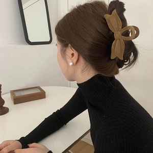 Brown velvet bow hair claw clip for women shown in a stylish updo hairstyle