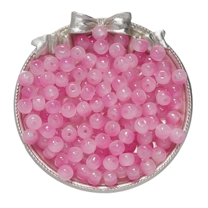 Detailed view of 8x7mm translucent pink apple beads stored in a silver gift container