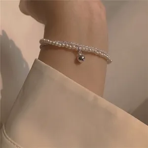 French luxury style double-layer bracelet with pearls, silver beads, and bell pendant