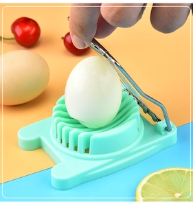 Action shot of green plastic egg slicer with metal wires cutting a boiled egg