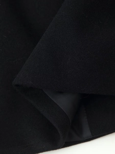 Détail de la texture du tissu en laine noire et de la doublure intérieure lisse