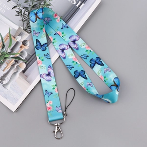 Detailed view of butterfly and floral print blue lanyard with silver metal hook hardware