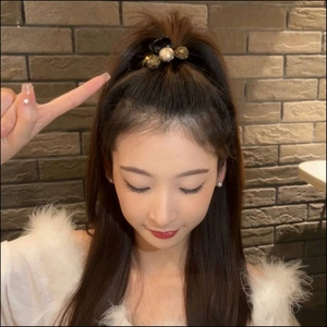 Elegant black hair claw clip with pearl and gold accents shown on a model's hair
