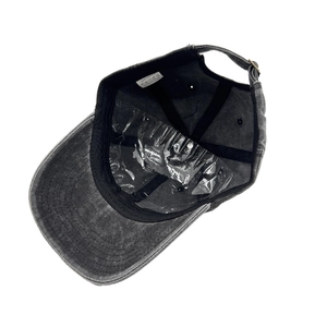 Detail view of cotton washing label and metal buckle on washed grey baseball cap