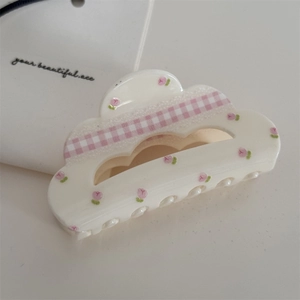 Creamy white hair claw clip with pink floral plaid bow design on a clean background