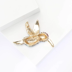 Macro shot of hummingbird brooch back showing pin mechanism and gold alloy structure