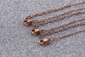 Close-up of rose gold necklaces showing lobster clasp and extension chain details