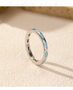 Gros plan d'une bague en argent S925 sertie de pierres turquoise sur socle en pierre