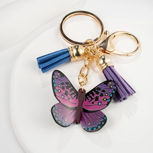 Close-up of butterfly pendant keychain with purple wings and colorful silk tassels