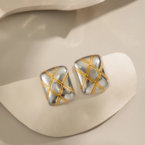Detail of square two-tone stud earrings with gold lattice pattern on silver base