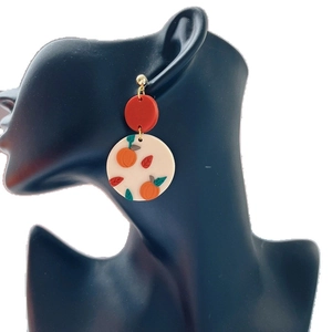 Handmade clay earrings featuring orange pumpkin patterns and red studs for Halloween