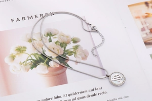 Macro detail of silver stainless steel necklace with circular Virgo zodiac sign pendant