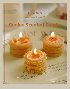 Detalle de velas aromáticas con forma de galleta encendidas en un plato decorativo