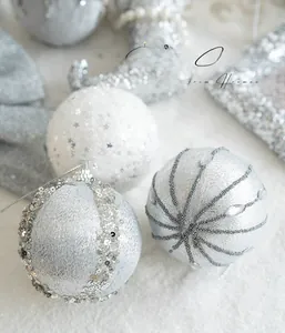 Detailed view of silver Christmas balls with silk thread, sequins and beads on white fur