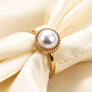 Detail of 10mm golden pearl ring on silk fabric with elegant milgrain setting
