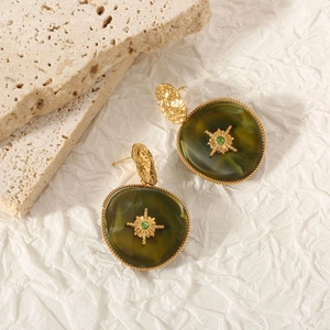 Detail of vintage resin earrings with green marble texture and gold braided metal border