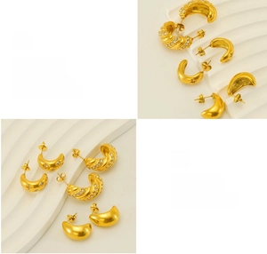 Macro shot of gold plated chunky C-shaped earrings with zircon inlay and polished finish