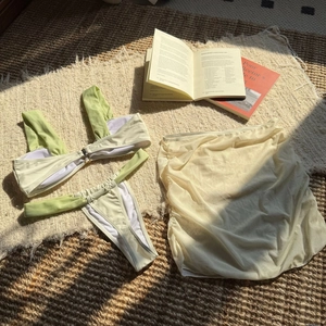 Detailed close-up of a three-piece contrast bikini with cream mesh cover-up skirt