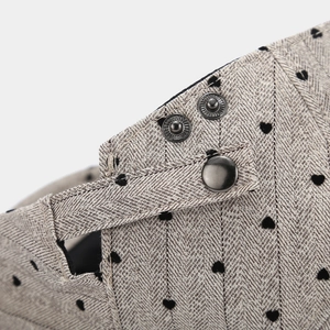 Detail of adjustable snap closure and heart pattern on grey herringbone fabric