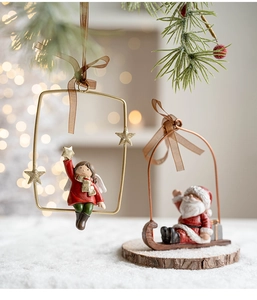 Detail of angel girl in golden frame and Santa on a wooden sleigh Christmas ornaments