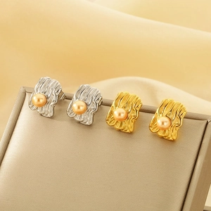 Detailed macro view of irregular texture rectangle stud earrings with shell pearls