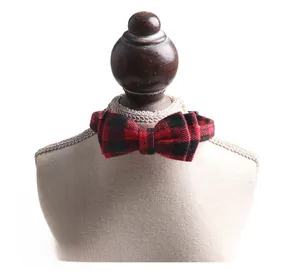 Detail of red and black plaid pet collar with bowknot on a small model stand