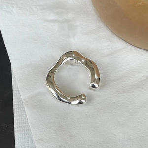 Macro shot of 925 sterling silver ring showing irregular organic wavy lines and high polish