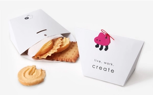 Detail of creative trapezoid paper food box with red tassel and assorted cookies
