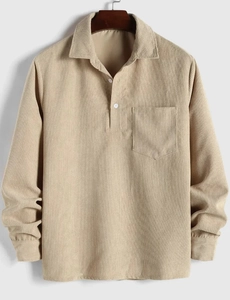 Primer plano de camisa de pana caqui con textura, bolsillo de pecho y botones blancos
