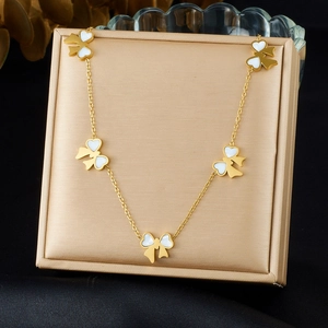 Elegant gold plated stainless steel necklace featuring five white bow charms on silk