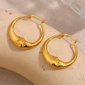 Makroaufnahme von 18K vergoldeten Edelstahl-Ohrringen mit Mondgesicht-Design