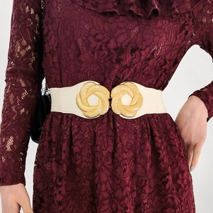 Detail of white elastic waist belt featuring a gold floral spiral interlocking buckle