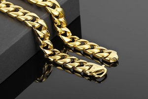 Close-up of 15mm 18K gold plated stainless steel Cuban chain with engraved clasp detail