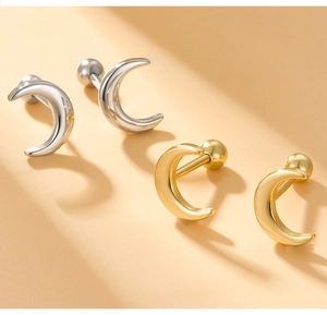 Macro shot of minimalist moon screw back earrings in gold and silver finish