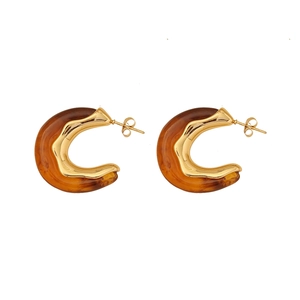 Chic vintage C-shaped earrings with gold metal and amber resin texture on white background
