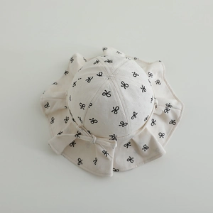 Detail eines Baby-Sonnenhuts mit Jacquard-Stoff, schwarzen Schleifen und Rüschenkante