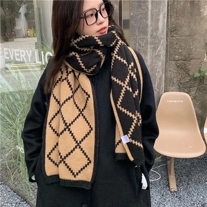 Close-up of black and camel checkered knit scarf with classic diamond plaid pattern