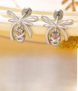 Macro detail of silver bow earrings with pink zircon and 0.8x6mm titanium steel posts