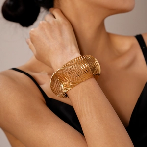 Detailed view of layered golden spiral cuff bracelet with metallic geometric texture