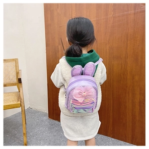 Detail of purple kids backpack with sequin rabbit ears and a pink mesh bow on a model
