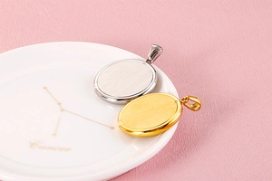 Detail view of gold and silver brushed metal oval charms on a decorative ceramic tray