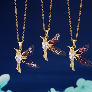 Three gold hummingbird pendant necklaces with gradient wings and heart crystal detail