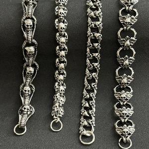 Detailed macro view of four silver skull link chains with polished vintage metal finish